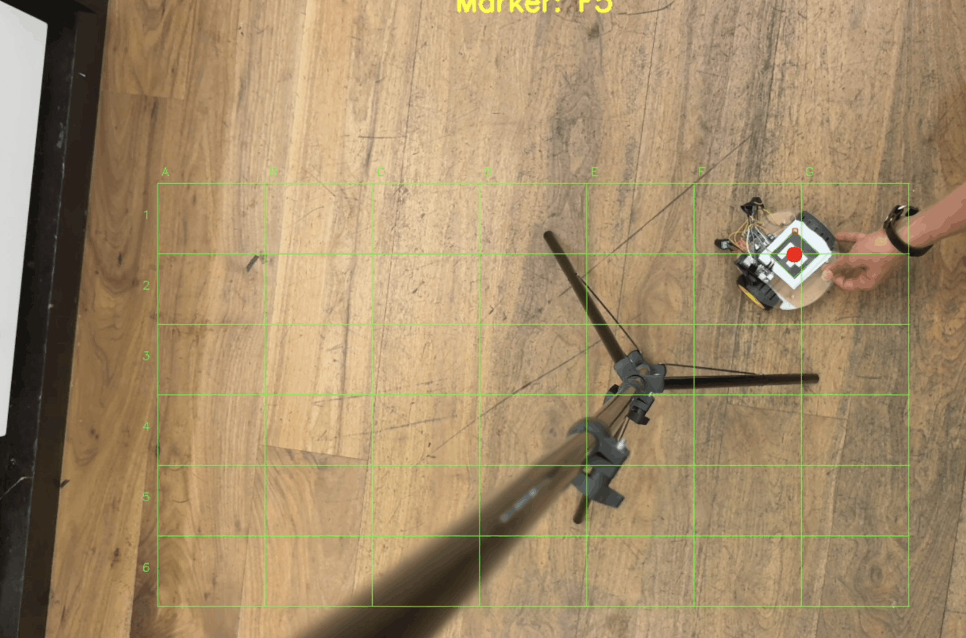 Overhead camera view with a green coordinate grid tracking a robot